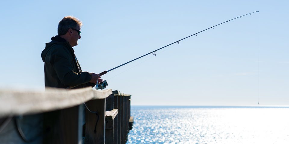 Man fishing off a pier on the North Carolina coast