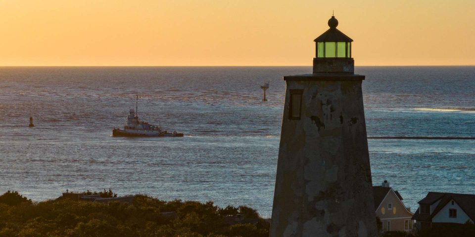 Lighthouse on coast overlooking ocean at sunset